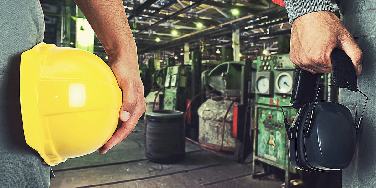 Workers holding a hardhat and earmuffs