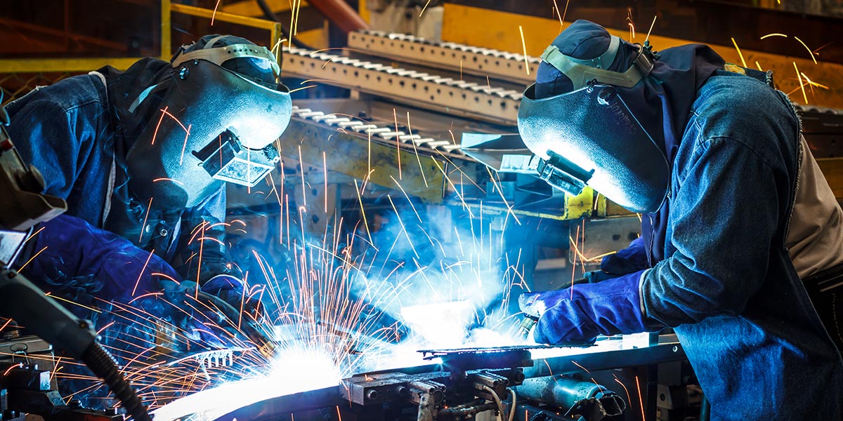 Workers welding and sparks flying up