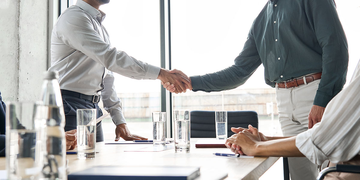 people shaking hands in business meeting