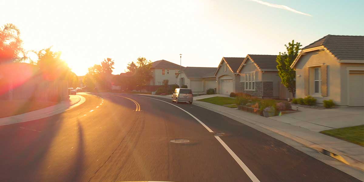 A road winding through residential homes.
